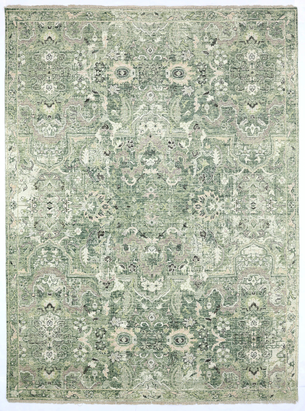 Green and beige patterned rug on a plain background