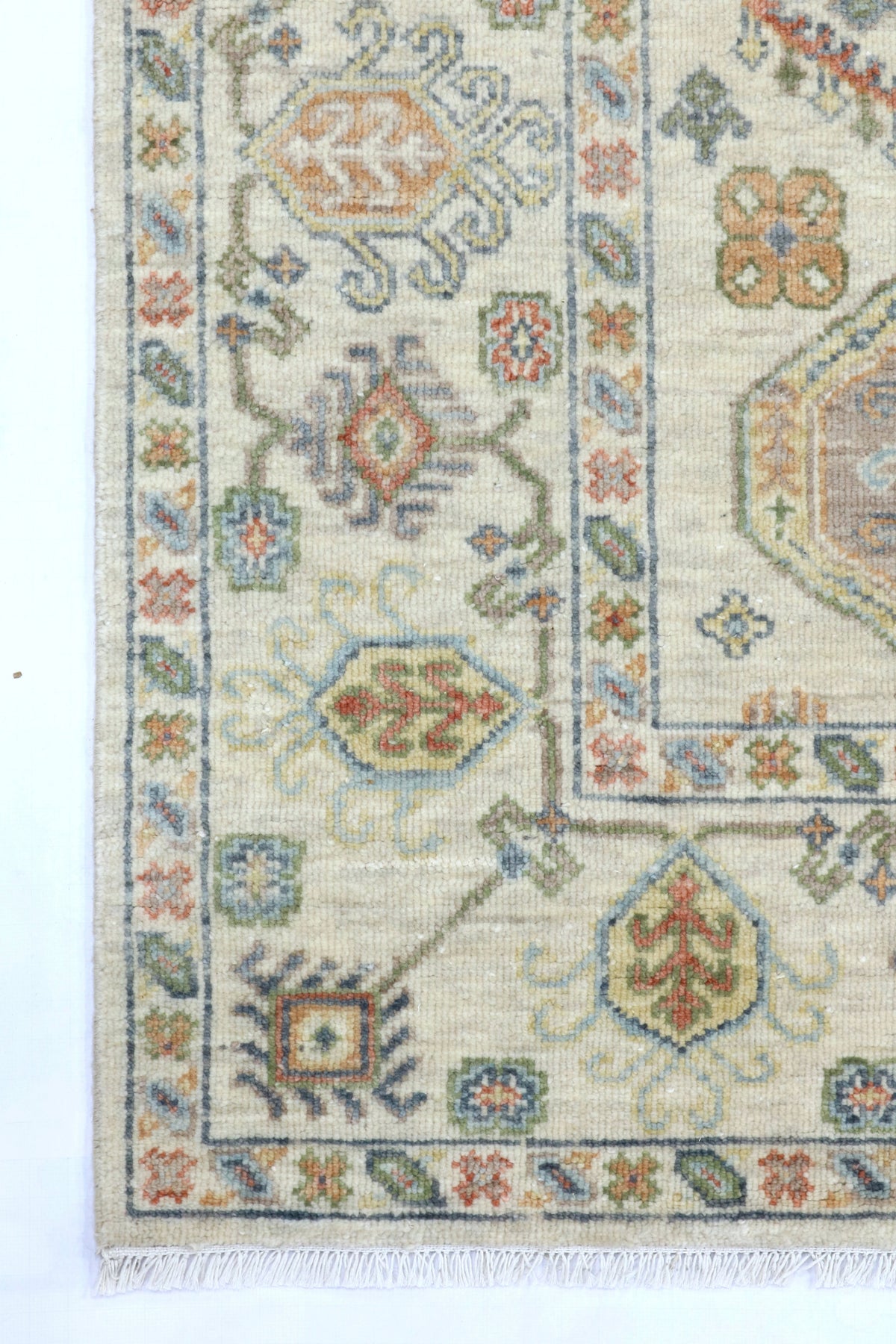 Close-up of a patterned rug with intricate designs on a white background